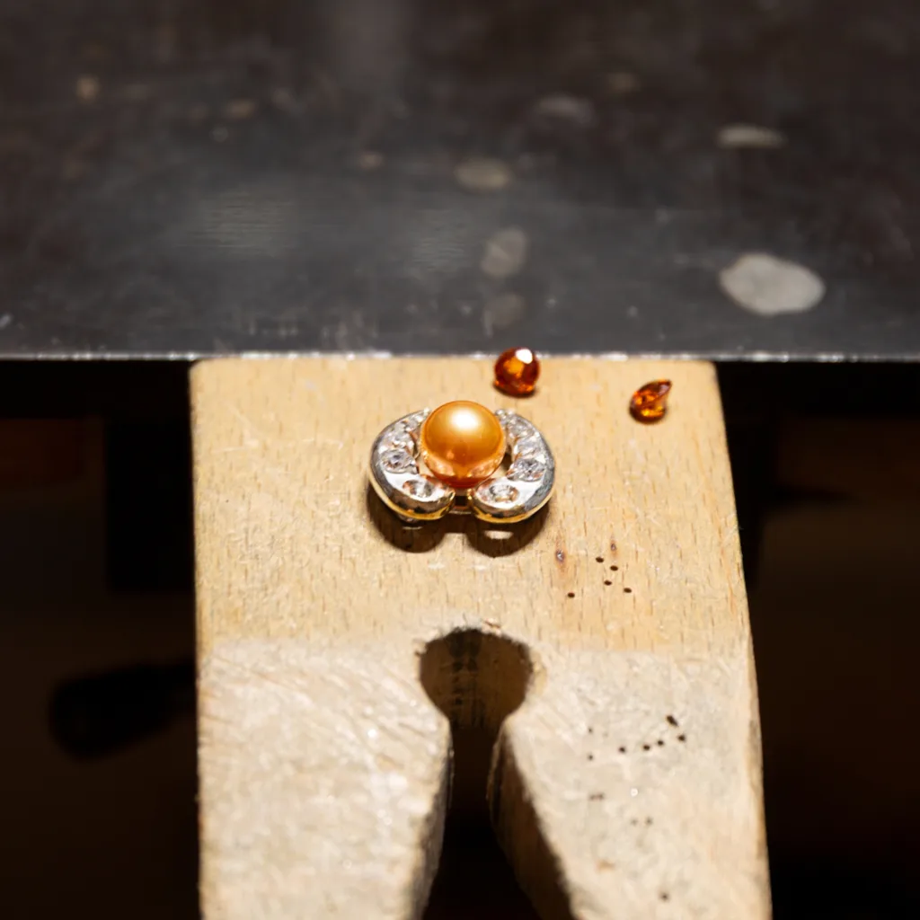 Gemstone set in a handmade brooch, guiding the overall design