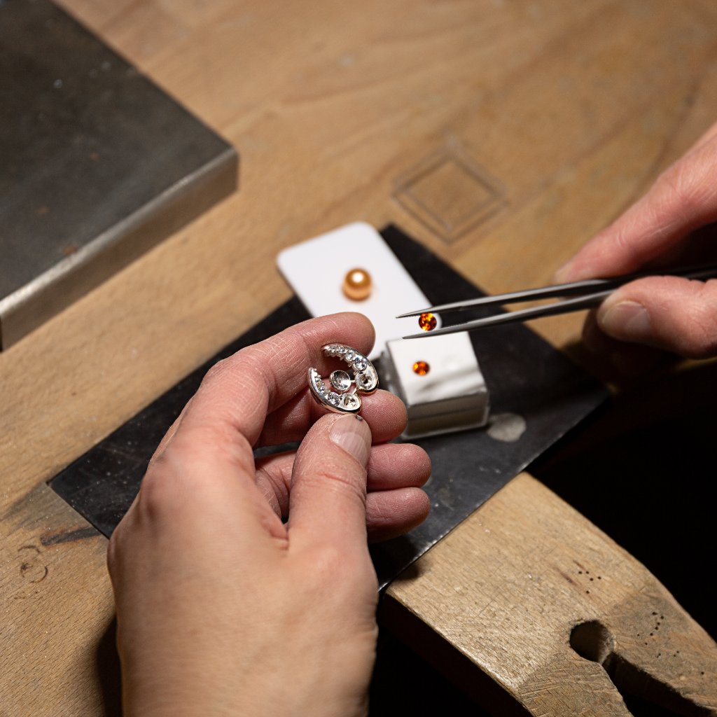 Handen van de maker aan het werk in het atelier bij het vervaardigen van een handgemaakt juweel